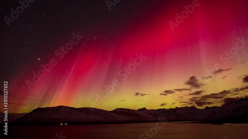 Majestic 4K Horizontal Timelapse of Red and Yellow Northern Lights Shimmering over Snowy Mountains and Arctic Lake in Iceland