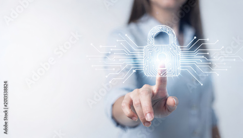 Digital Security: A person's hand pointing at a glowing padlock, symbolizing cybersecurity in a technological landscape, emphasizing data protection and secure access.