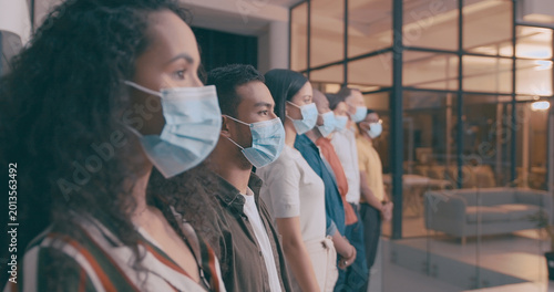 Team, row and business people with mask in office, safety compliance or virus prevention with cover. Colleagues, line and protection from disease with ppe, regulations and health protocol at night