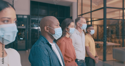 Tableau sur toile Man, team and business people in office with mask, safety regulations and virus prevention at night