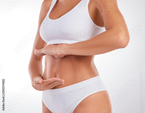 Slika na platnu Hands, underwear and stomach of woman in studio for wellness, gut health and digestion