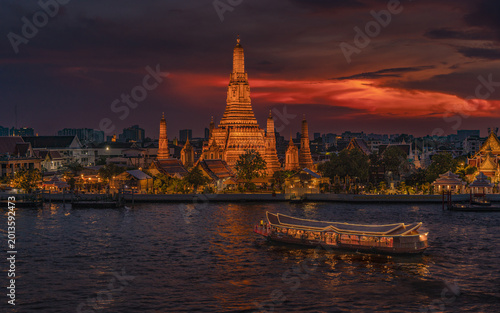 Obraz na płótnie Majestic Wat Arun temple at sunset with golden sky over Chao Phraya River, Bangkok, Thailand