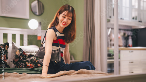 Φωτογραφία Adult asian woman choosing bed home interior shopping buying new furniture for b