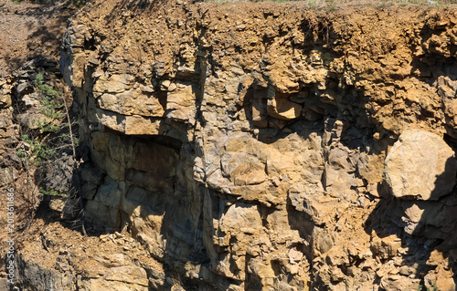 Cuadro en lienzo Layered sedimentary rock face with rough texture and shadows