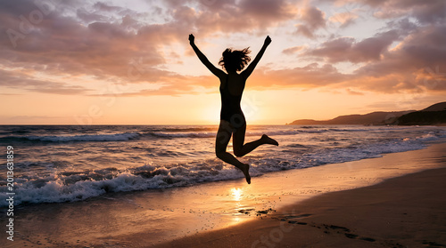 Silhouette of Woman Jumping on Beach at Sunset Freedom Concept