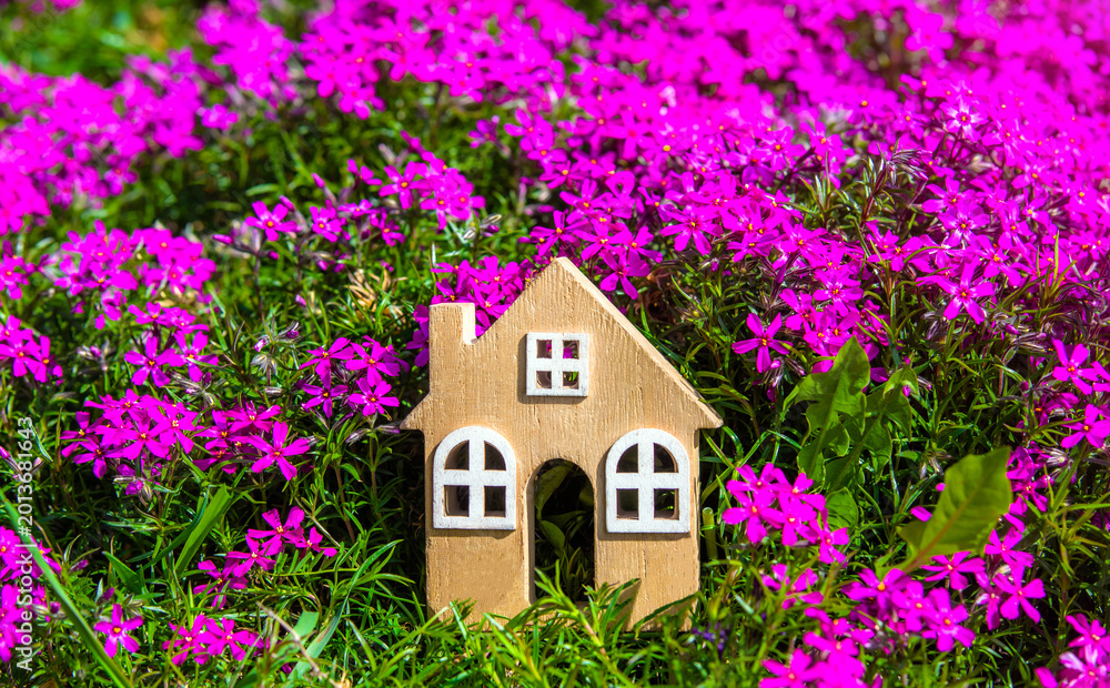 Naklejka premium The symbol of the house on the background of purple flowers 