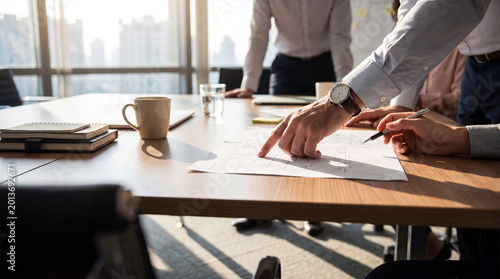 Картината върху платно Close-up photograph of business professionals collaborating, with one person pointing at a document during a meeting
