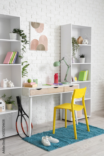 Interior of children's room with workplace and shelf units