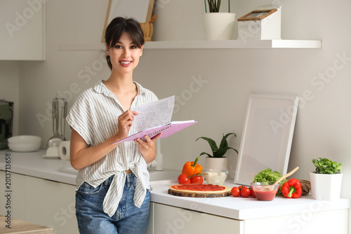 Young woman with recipe boo...