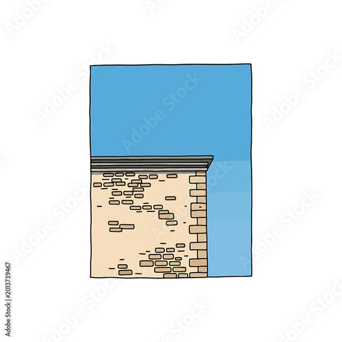 Corner of ancient stone building against clear blue sky