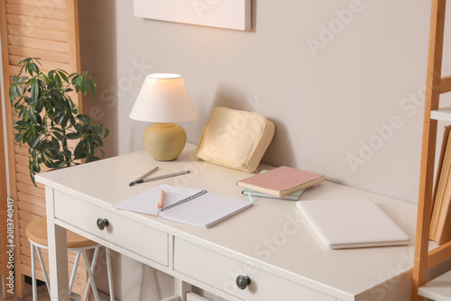 Student's workplace with notebooks and laptop in room