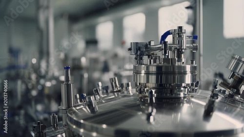 Stainless steel bioreactor vessels and complex piping systems operating within a sterile laboratory, supporting biotechnology processes and medical research development