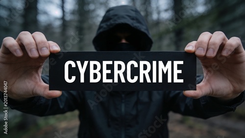 Slika na platnu Hacker in Black Hoodie Holding Cybercrime Sign in Dark Forest Background , Digit