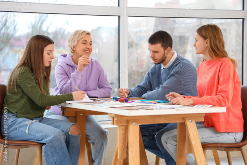 Mature art teacher with students drawing at school