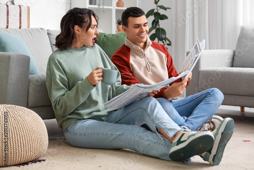 Young couple with newspaper...