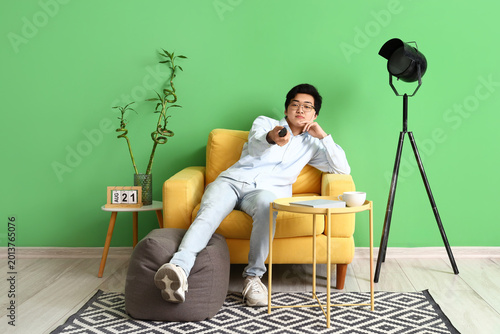 Young Asian man watching TV...
