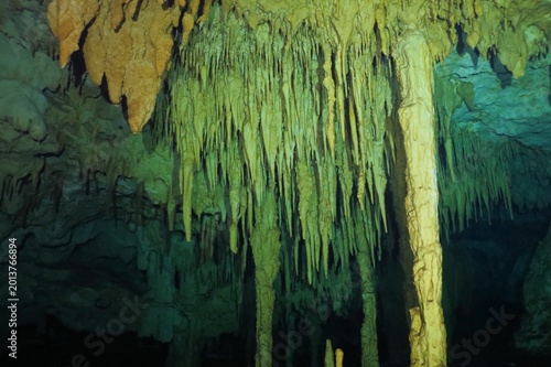 Cave ceiling with limestone decoration. Cenote with column and stalactites. Underwater tunnel. Underwater photo from cenote exploration. Cave diving, rocky formation.