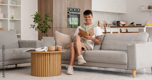 Young man reading book on s...