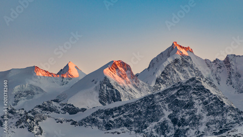 Fotografi High mountain landscape with peaks illuminated by the last sun