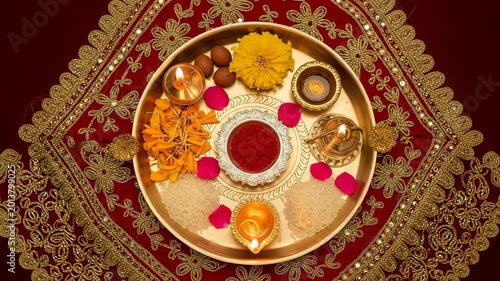Traditional Indian prayer thali with a lamp, flowers, and ritual powders