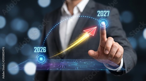 Businessman touching holographic growth chart with paper plane for business target achievement and future strategy planning from 2026 to 2027 in a professional corporate environment