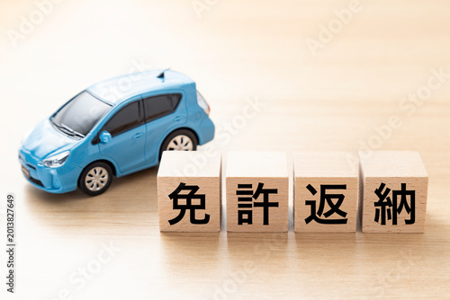 「免許返納」と書かれたブロックとエコカー
