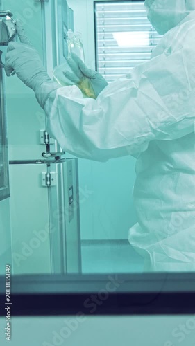 In a high-tech cleanroom within the pharmaceutical industry, a diverse team of researchers works diligently in the medical laboratory, examining a crucial specimen.