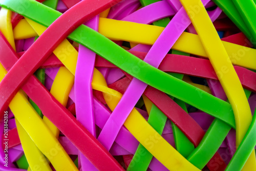 Intertwined colorful rubber bands forming a dynamic and flexible background pattern