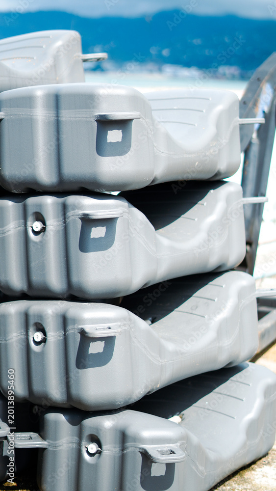 Fototapeta premium A stack of gray modular plastic floating dock sections in a harbor area