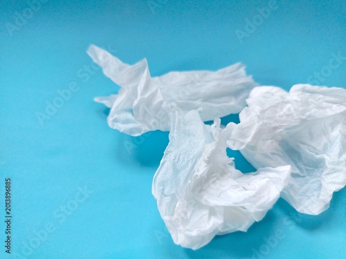 crumpled used paper tissue on blue