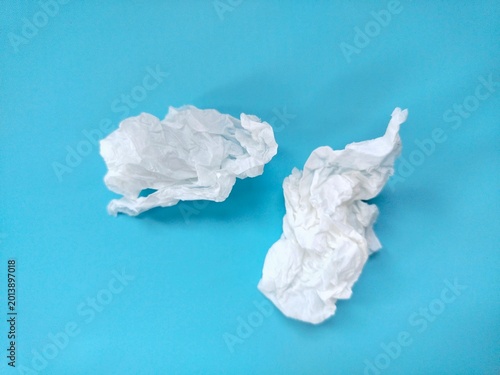 crumpled used paper tissue on blue