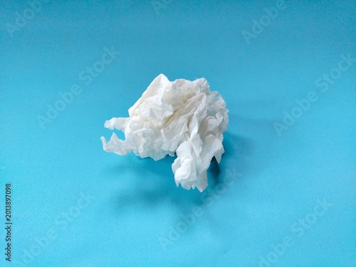 crumpled used paper tissue on blue