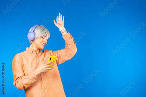 Young person enjoying music dancing with smartphone