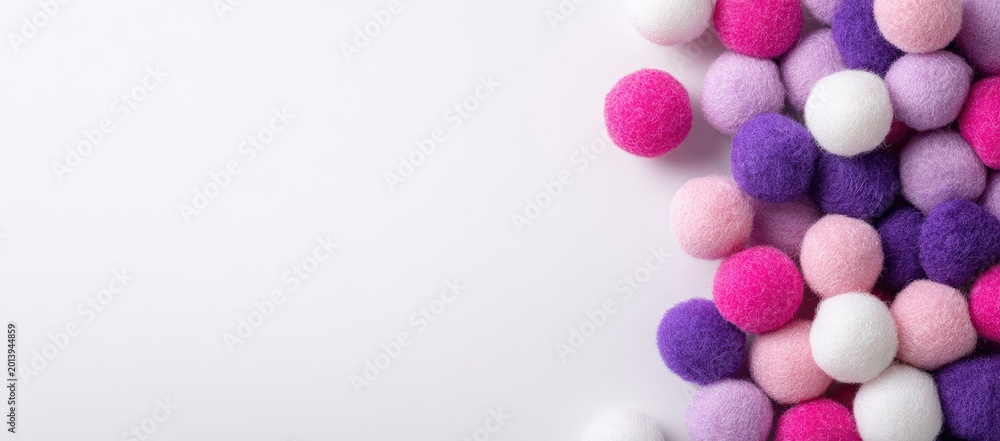 Obraz premium Pile of fluffy pom-poms in white, pink, purple hues on white surface, right side