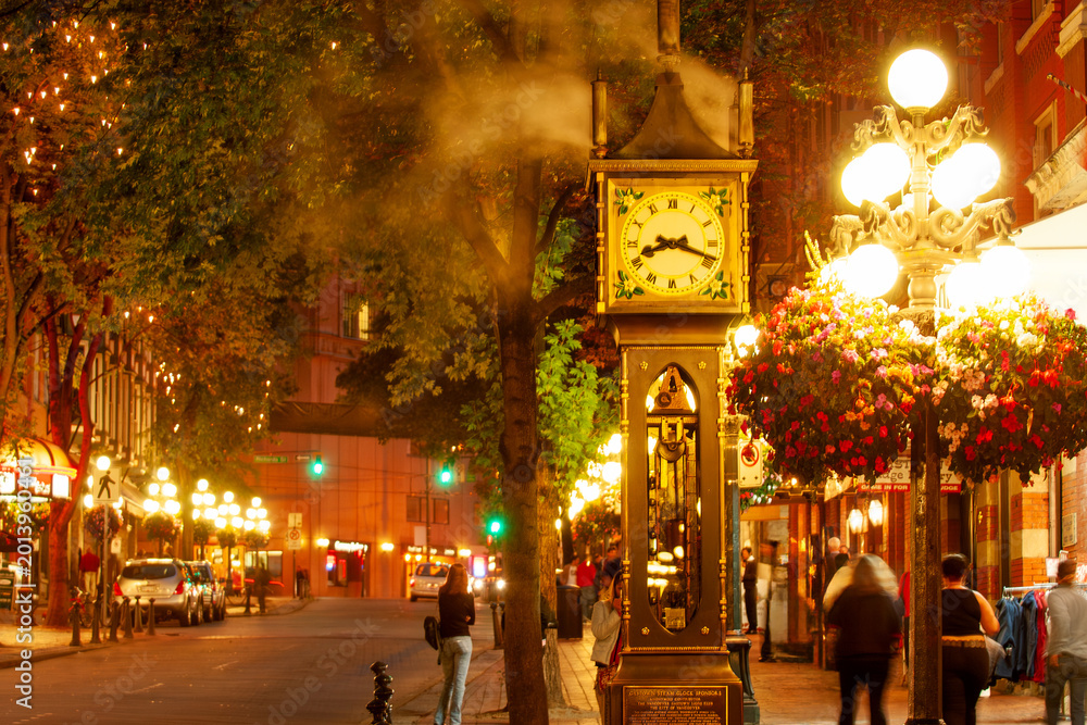 Naklejka premium Famous steam-powered clock at the corner of Water Street and Cambie Street, surrounded by night life in Gastown oldest neighborhood of Vancouver, Canada