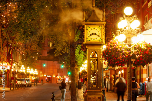 Famous steam-powered clock at the corner of Water Street and Cambie Street,  surrounded by night life in Gastown oldest neighborhood of Vancouver, Canada