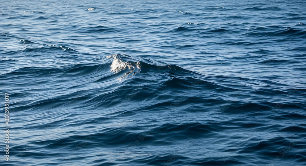 Naklejka premium Ocean waves with sunlight on water surface