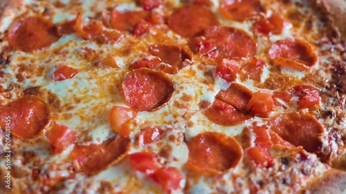 A close-up of an Italian pepperoni pizza spinning in a circle