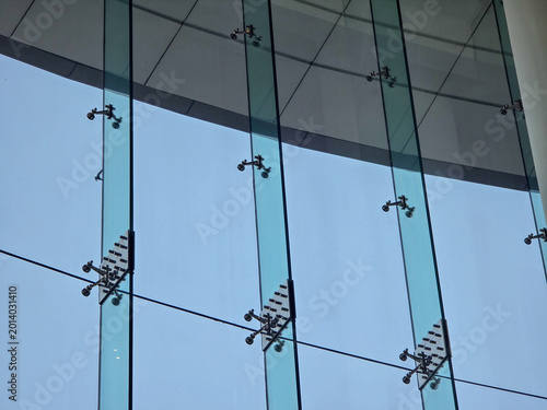 фотографія Modern glass facade of commercial building featuring structural spider fitting c