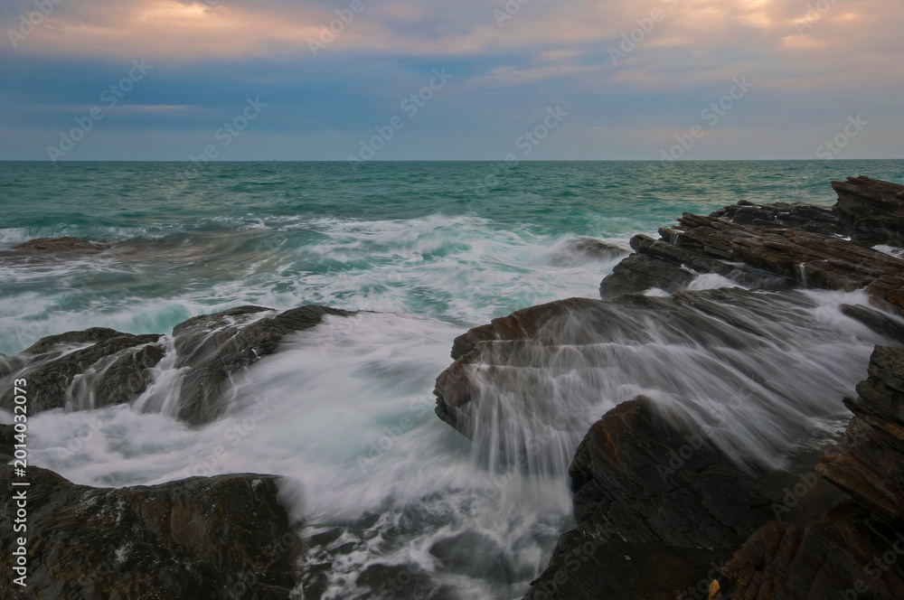 Obraz premium Sea waves and rocks in the evening.