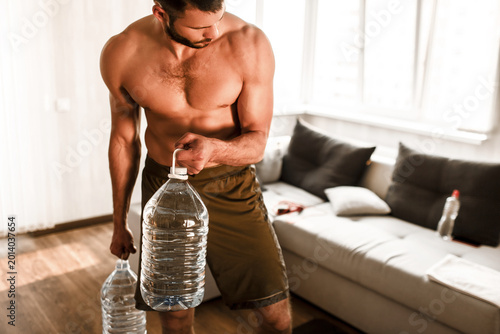 Fotografie Young man doing sport workout in room during quarantine