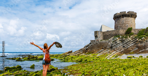 Traveler happy woman traveler enjoying the view of fort de socoa in saint-jean-de-luz. Travel destination, tour tourism in France