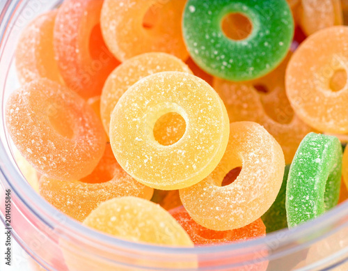 Tropical fruit flavored gummy rings in a bulk candy bin in a store. Ai