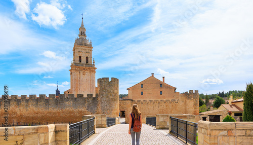 Fotografía Traveler woman crossing bridge to medieval walls and cathedral tower in el burgo