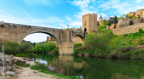 Foto medieval san martin bridge over tagus river with reflection in toledo spain