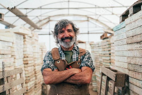 Foto Farmer senior man working in his farm and greenhouse