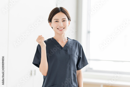 ガッツポーズをしているスクラブを着た笑顔の日本人女性