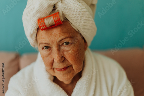 Canvas Print Senior woman with hair wrapped in a towel after shower.