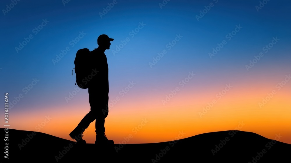 Fototapeta premium Silhouette of a Hiker with Backpack Against a Colorful Sunset Sky Over Dunes in Scenic Landscape, Evoking Adventure and Exploration in Nature