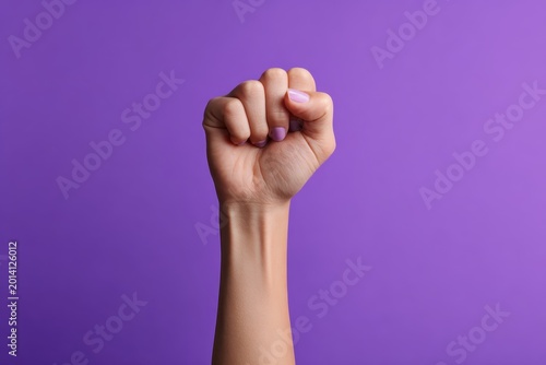 feminist symbol with a raised fist inside on a purple background representing female empowerment movement